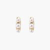 14K gold-plated curved stud earrings with three white freshwater pearls aligned vertically on cream background