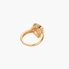 Teardrop-shaped gold-plated ring with turquoise enamel flowers and crystal pavé detail on cream background