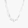 Sterling silver multi-strand necklace with three brushed round beads on cream background